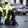 Police detain a man after he ran in front of UK Prime Minister Boris Johnson's car, (AP)