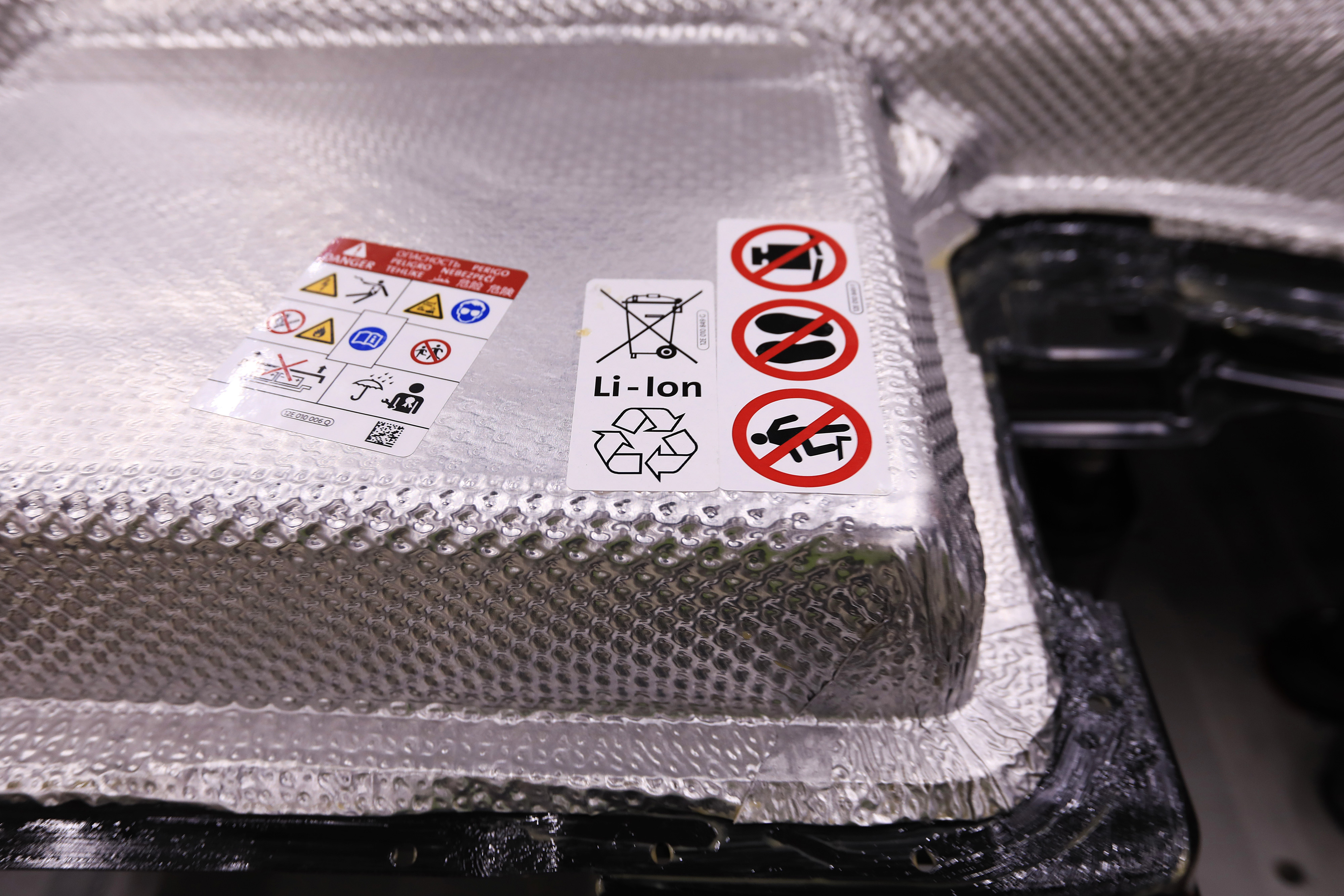 A recycling symbol sits on a lithium-ion battery pack of a Volkswagen e-Golf electric automobile. A recycling symbol sits on a lithium-ion battery pack of a Volkswagen e-Golf electric automobile.