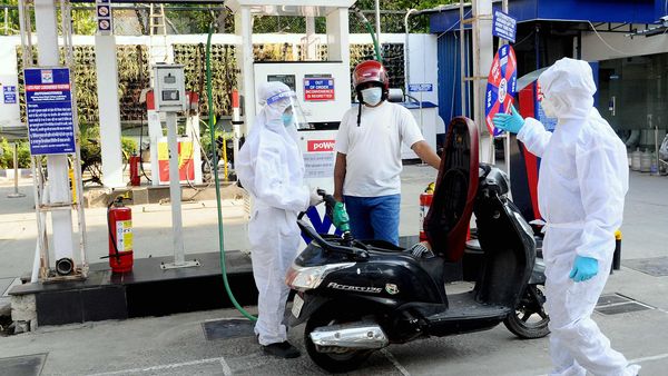 Petrol pump workers wear protective suit on duty during the nationwide Covid-19 lockdown in New Delhi.