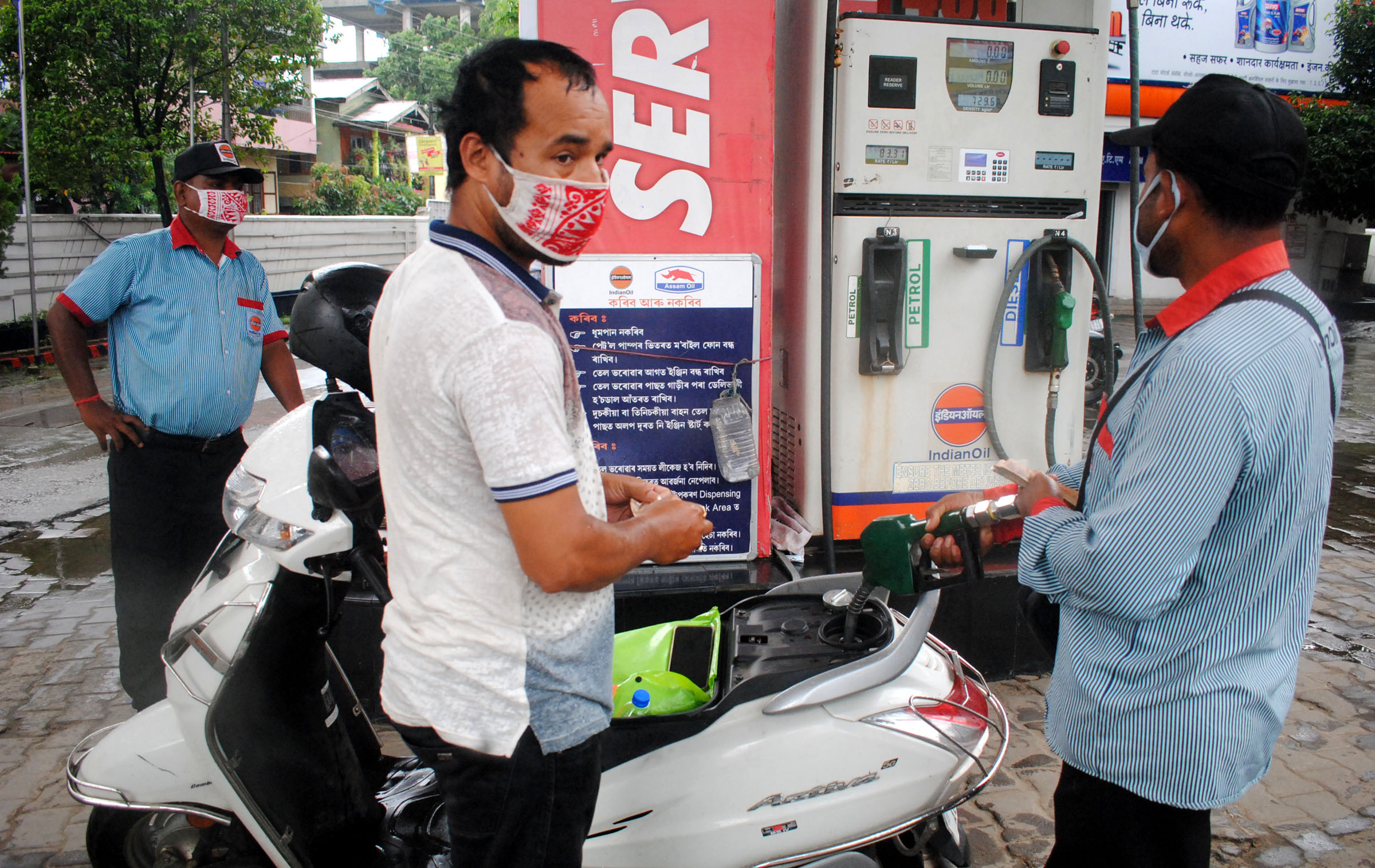 An employee adds fuel in a scooty, at a petrol pump, in Guwahati on Saturday. An employee adds fuel in a scooty, at a petrol pump, in Guwahati on Saturday.