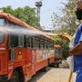 A worker sprays disinfectant on a bus outside at a depot during the fifth phase of Covid-19 lockdown, in Nagpur, Maharashtra. (PTI)