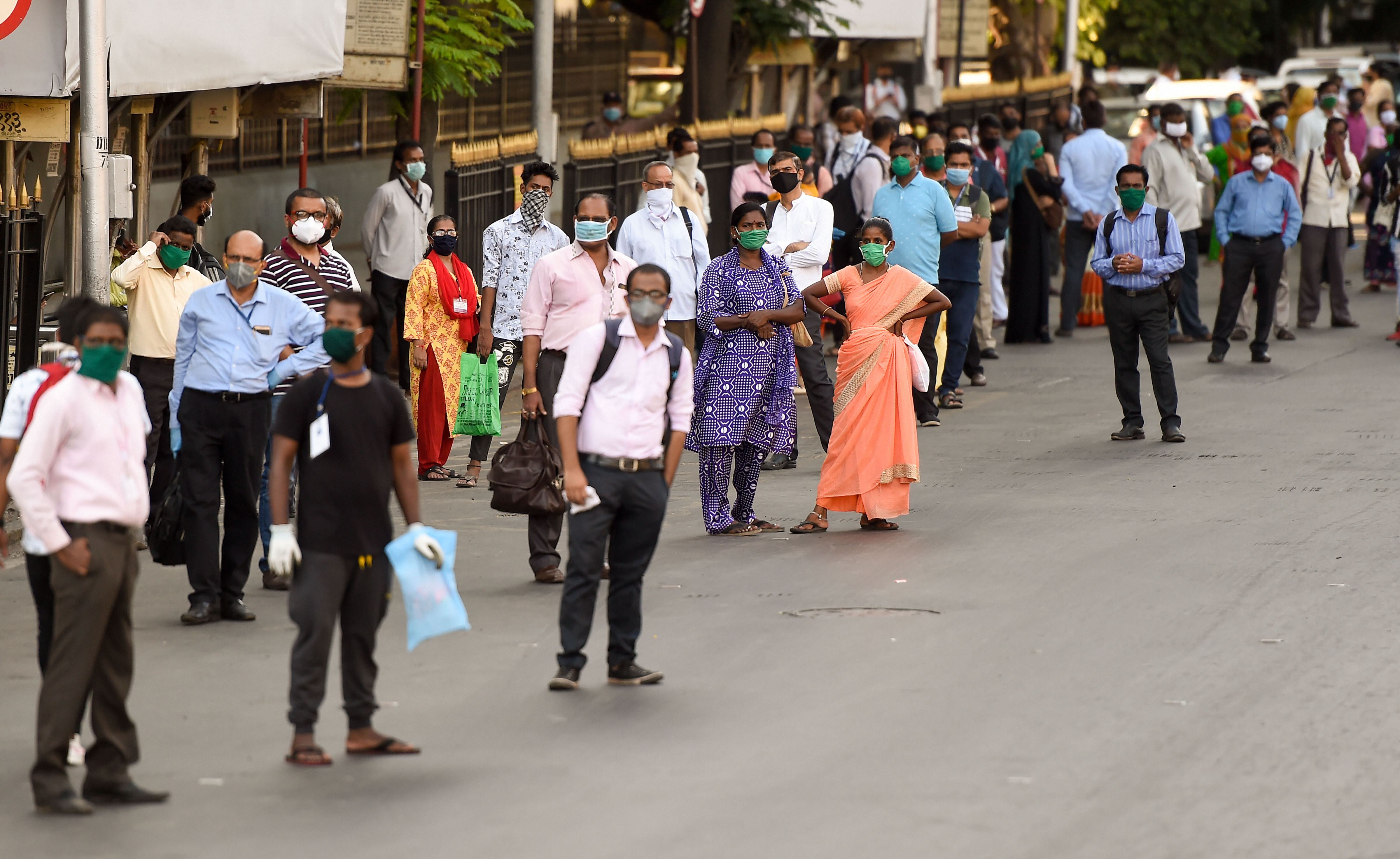 People wait for BEST bus for local transport, during nationwide lockdown as a preventive measure due to the coronavirus pandemic, at CSMT in Mumbai,
