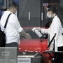 A showroom assistant wearing a protective mask and face shield, right, sprays hand sanitizer into a visitor's hands at the entrance of Nissan Motor's Ginza showroom in Tokyo. (Bloomberg)