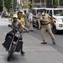 Mumbai: A policeman raises his baton at a commuter during checking amid Covid-19 in Byculla. (PTI)