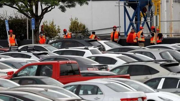 Tesla workers in orange vests are seen outside the company's California plant. (REUTERS)