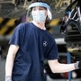 A worker wears a protective face mask and shield on the assembly line inside the Mercedes-Benz AG automobile plant, operated by Daimler AG. (Bloomberg)