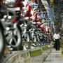 A worker walks beside newly built motorbikes at the Bajaj Auto Ltd. plant in Pune, about 130 km (82 miles) from Mumbai. 