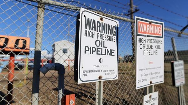 File photo - Signs warning of the presence of oil pipelines are seen on a fence outside facilities run by Enbridge, Kinder Morgan and Suncor in Sherwood Park near Edmonton, Alberta, Canada. (REUTERS)