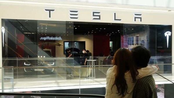 Of dreams, love and a Tesla: A couple looks at a Tesla dealership in Hanam, South Korea. (REUTERS)
