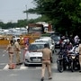 Police personnel check ID cards of commuters at Delhi Noida Border.