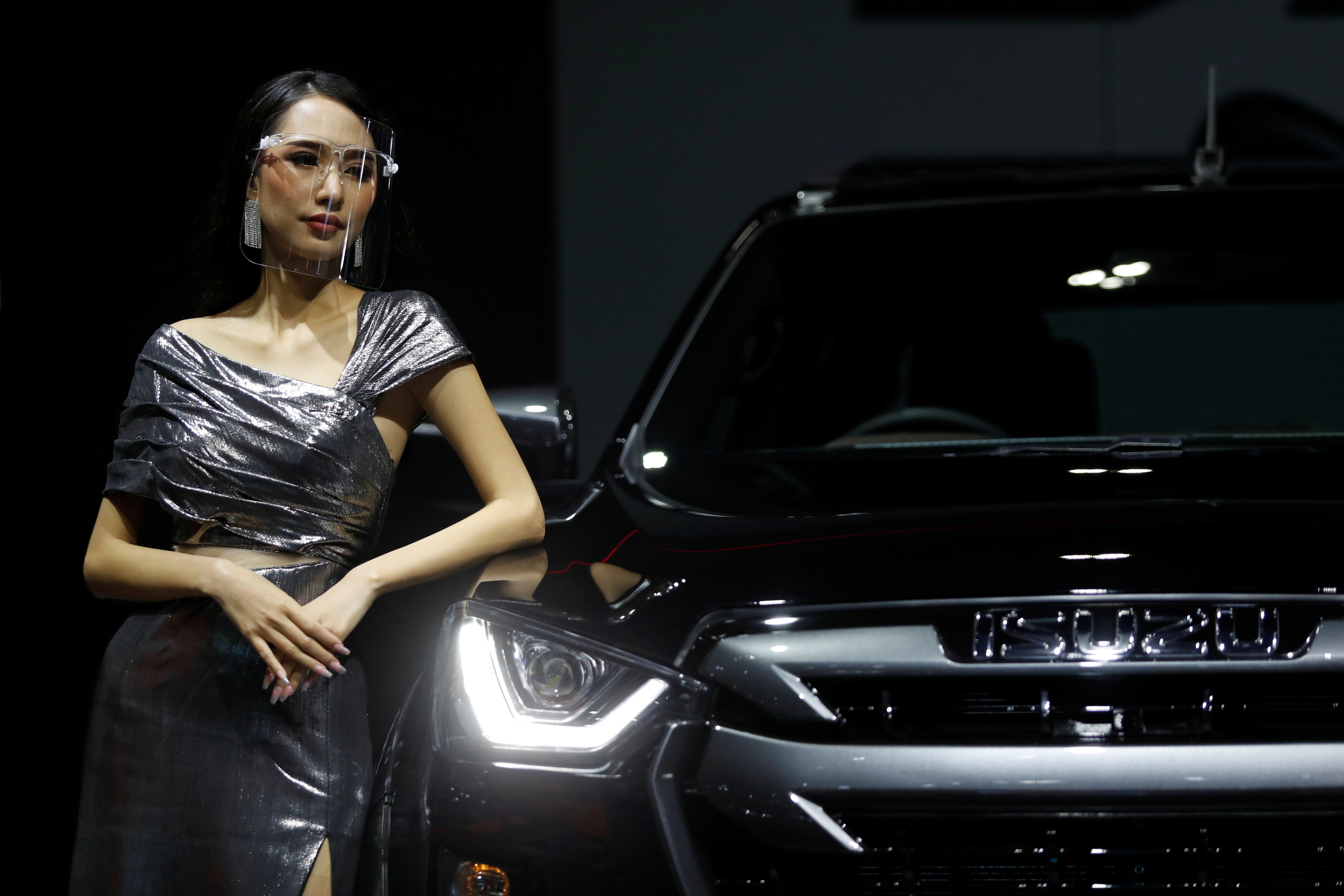 A model leans against a Isuzu vehicle during the media day of the 41st Bangkok International Motor Show after the Thai government eased measures to prevent the spread of the coronavirus disease (COVID-19) in Bangkok, Thailand July 14, 2020. REUTERS/Jorge Silva
