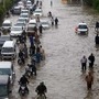 Vehicles drive through a flooded road caused by heavy rainfall in Karachi. (AP)