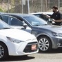 A car dealer wearing a protective mask shows a vehicle to customers at a used car dealership. (Representational photo) (Bloomberg)