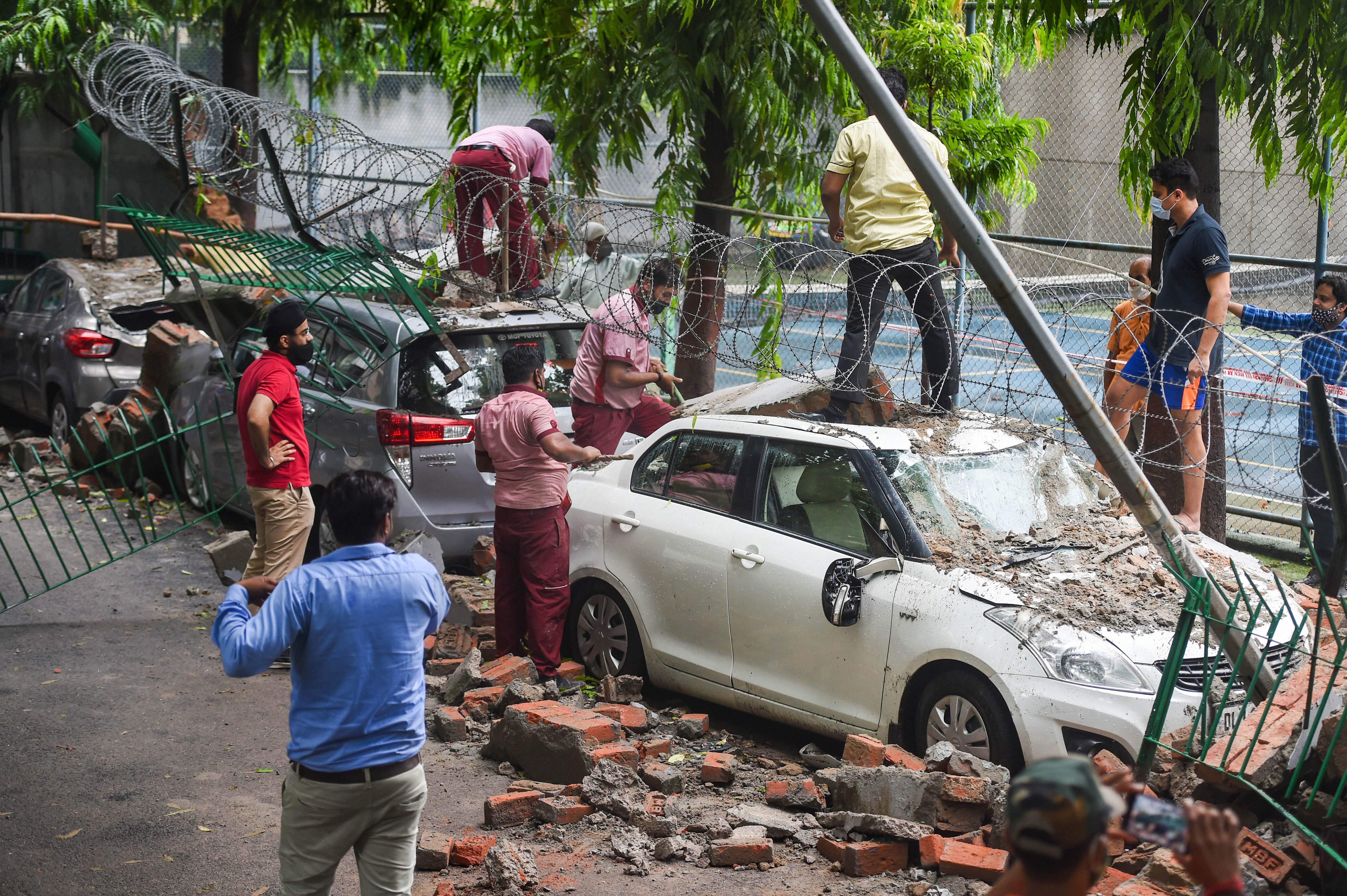 Vehicles parked along the wall were heavily damaged after it came crashing down. Vehicles parked along the wall were heavily damaged after it came crashing down.