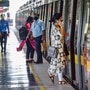 Commuters board a metro train as Delhi Metro resumes operations in a graded manner. (PTI)
