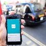 A London taxi passing as the Uber app logo is displayed on a mobile telephone in London. (File Photo) (REUTERS)