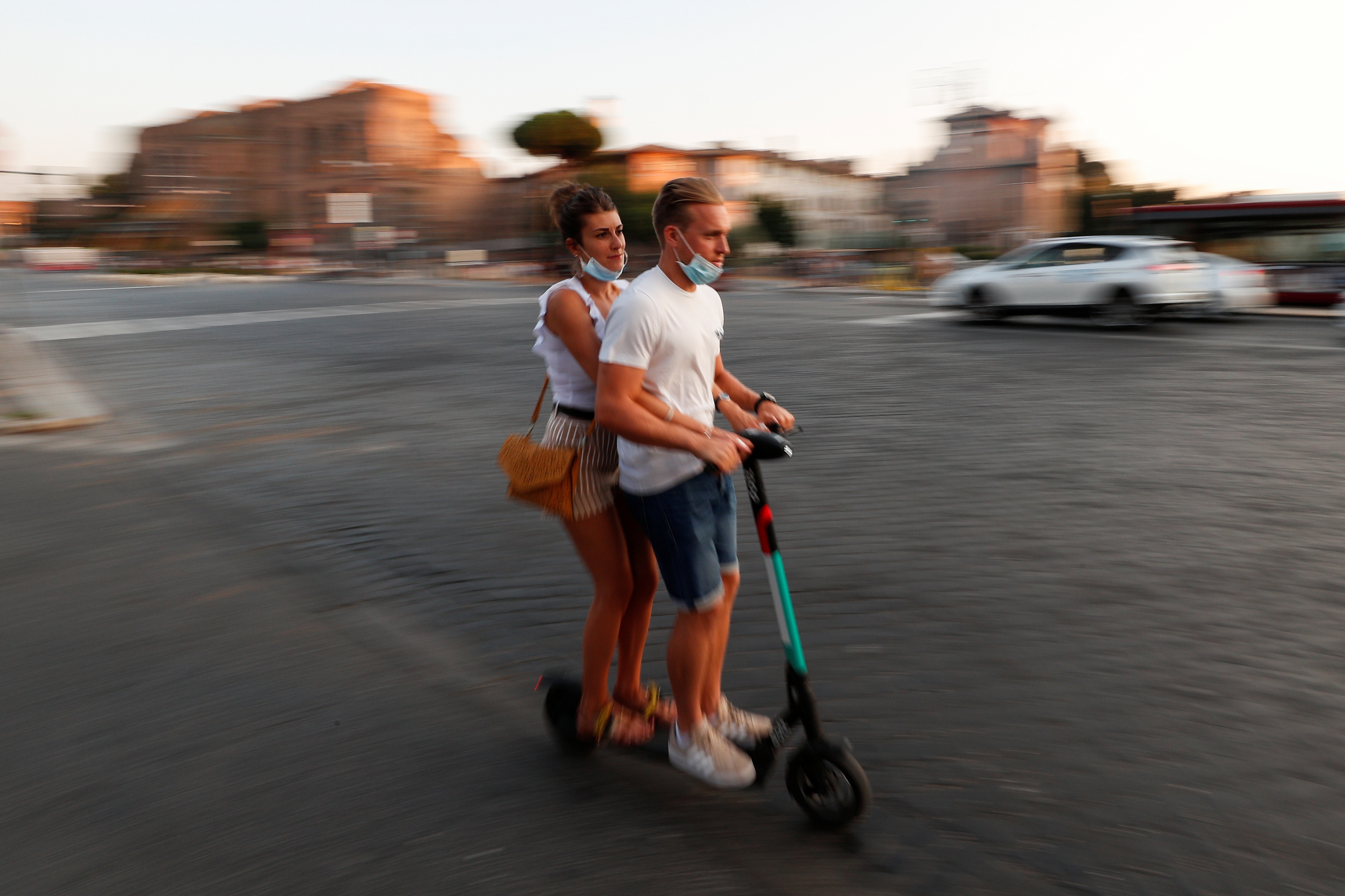 People ride an electric scooter near the Colosseum in Rome, Italy, September 18, 2020. 