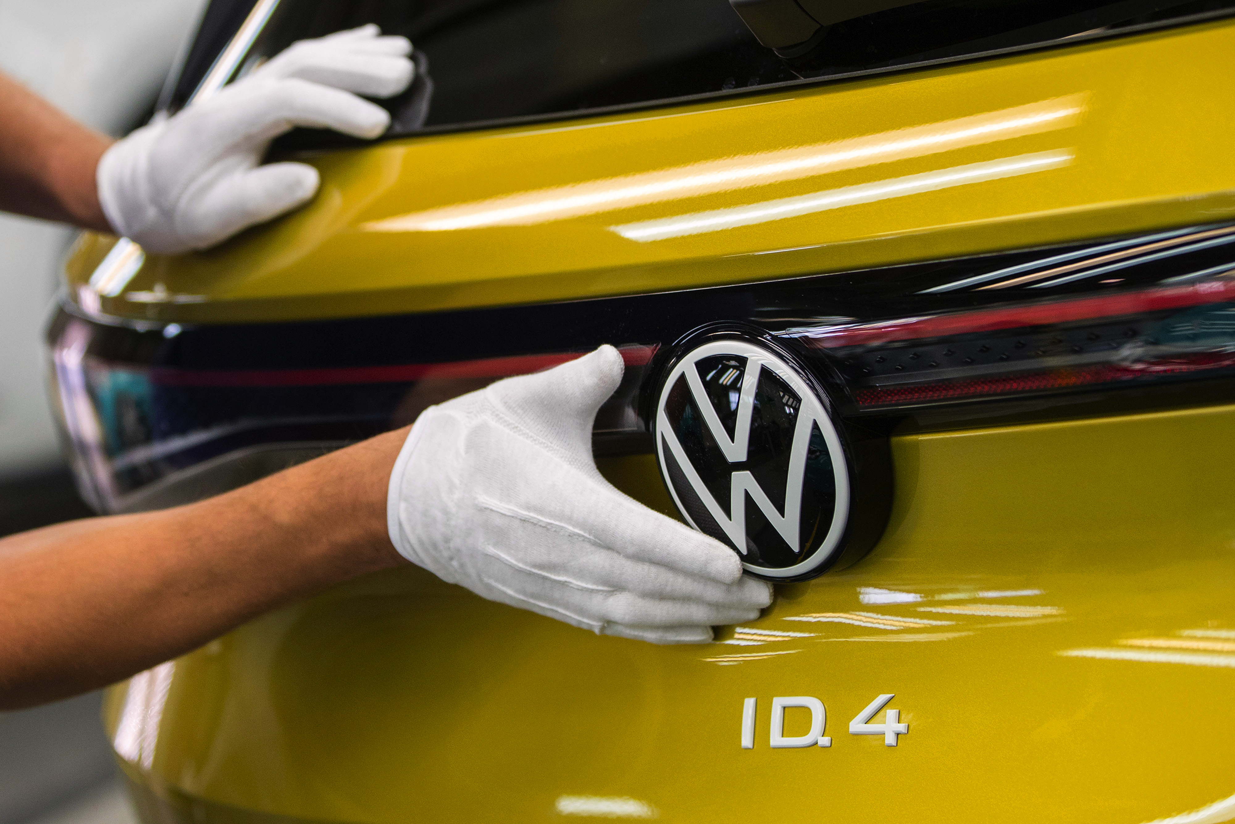 An employee carries out final quality checks on a Volkswagen ID.4 sports utility vehicle (SUV) at the Volkswagen AG electric automobile factory in Zwickau, Germany.