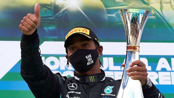 Mercedes driver Lewis Hamilton celebrates with a trophy on the podium after winning the Eifel Grand Prix. (REUTERS)