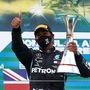 Mercedes driver Lewis Hamilton celebrates with a trophy on the podium after winning the Eifel Grand Prix. (REUTERS)