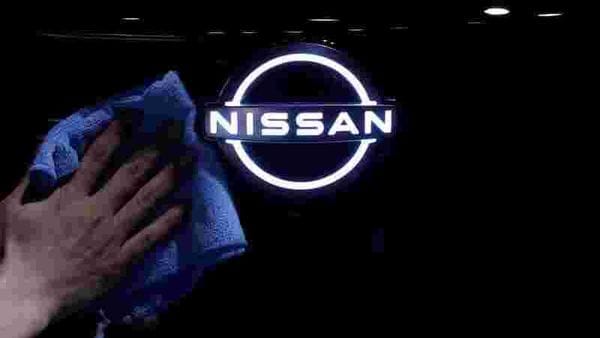 FILE PHOTO: A man wipes the brand logo of Nissan Motor on the front nose section of the company's new Ariya all-battery SUV (REUTERS)