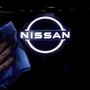 FILE PHOTO: A man wipes the brand logo of Nissan Motor on the front nose section of the company's new Ariya all-battery SUV (REUTERS)