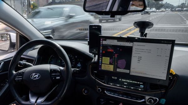 A photo taken on May 28, 2020 shows a safety driver sitting behind the wheel of a Rideflux 'self-driving' car in Jeju. - In a workshop that blends a corporate office with a tool-packed garage, South Korean company Rideflux are looking to take on the multi-billion-dollar giants of Uber, Tesla and Google parent Alphabet with a self-driving car of their own. Their modified Hyundai Ioniq, festooned with cameras and proximity sensors, is the first autonomous vehicle to go into regular service on public roads in the country. (Photo by Ed JONES / AFP) / TO GO WITH: SKorea-automobile-transport-technology, FOCUS by Kang Jin-kyu (AFP)
