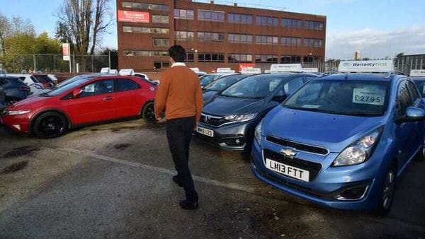 Ameen Sultani, general manager of used car dealer Nawaie Motoring Ltd, walks as he shows some of the older, cheaper vehicles in Hayes, Britain. (REUTERS)
