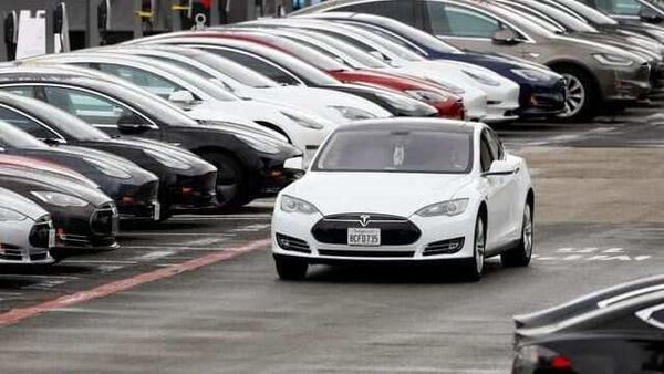 A Tesla Model S electric vehicle drives along a row of occupied superchargers. (File Photo) (REUTERS)