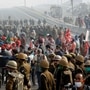 Farmers block a highway as police officers stand guard during a nationwide strike against the newly passed farm bills at the Delhi-Uttar Pradesh border in Ghaziabad, India, December 8, 2020. REUTERS/Adnan Abidi (REUTERS)