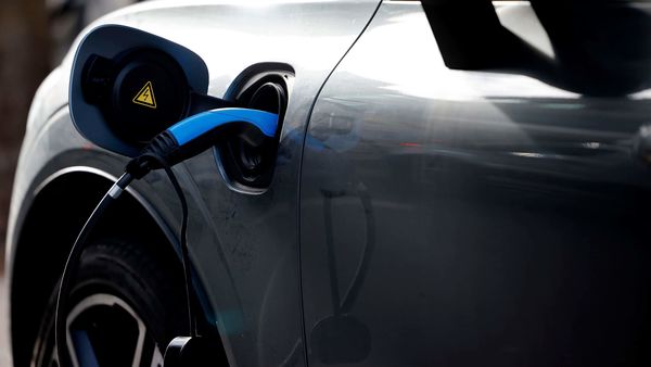 Representational image: A charging cable is pictured plugged into an electric car. (Photo by Tolga Akmen / AFP) (AFP)