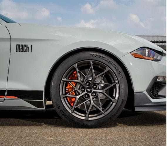 The long straight lines behind shorter, angled lines on the wheels of 2021 Mustang Mach 1 resemble bird's nest and bridge truss construction.