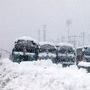 Trucks stranded at Srinagar-Jammu National highway during heavy snowfall, in Qazigund on Wednesday. (ANI Photo)