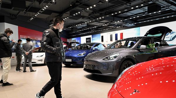 File photo of customers looking at a Tesla Model Y at a showroom in Beijing. (AFP)