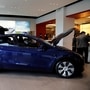 FILE PHOTO: Visitors wearing face masks check a China-made Tesla Model Y sport utility vehicle (SUV) at the electric vehicle maker's showroom in Beijing, China January 5, 2021. REUTERS/Tingshu Wang/File Photo (REUTERS)
