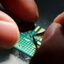 A researcher plants a semiconductor on an interface board during a research work to design and develop a semiconductor product at Tsinghua Unigroup research centre in Beijing, China, (REUTERS)