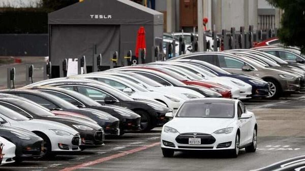 A Tesla Model S electric vehicle drives along a row of occupied superchargers at Tesla's primary vehicle factory. (File Photo) (REUTERS)