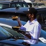 Waiters serve food to customers in their cars outside a restaurant in Kuwait City on March 9, 2021. (AFP)