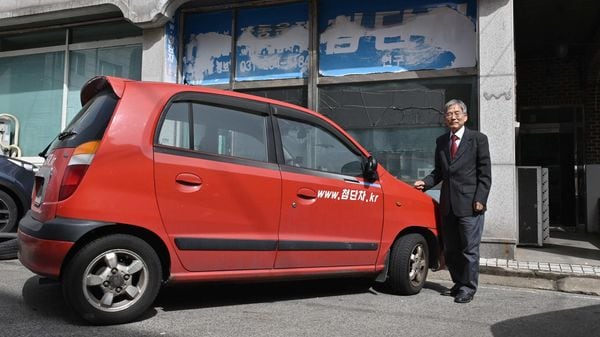 This picture shows retired South Korean professor Han Min-hong posing next to his 21-year-old self-driving car in front of his office in Yongin, south of Seoul. (AFP)