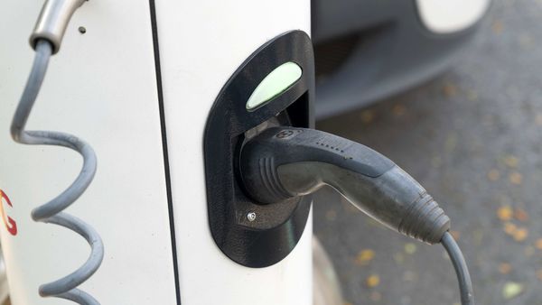 A charging plug is connected to an electric vehicle at a charging station. (File photo) (Bloomberg)