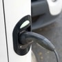 A charging plug is connected to an electric vehicle at a charging station. (File photo) (Bloomberg)