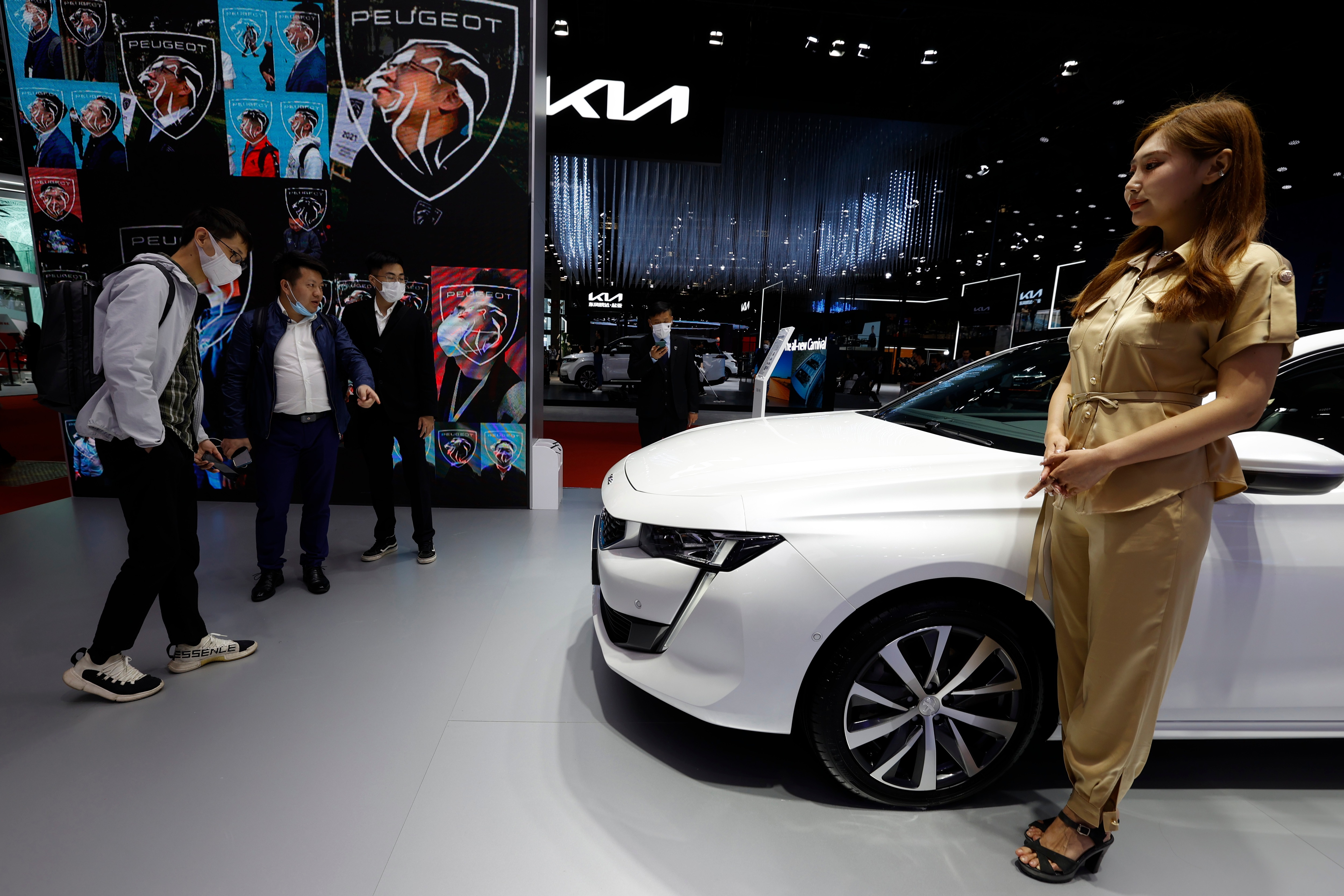 Visitors look at the latest cars on display during the Shanghai Auto Show in Shanghai on Monday, April 19.