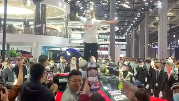 Screengrab from the video which shows a woman on top of a Tesla Model 3 at the Shanghai Auto Show. (Photo courtesy: Twitter/globaltimesnews)