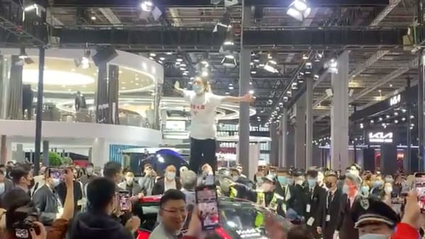 Screengrab from the video which shows a woman on top of a Tesla Model 3 at the Shanghai Auto Show. (Photo courtesy: Twitter/globaltimesnews)