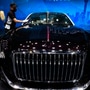 A worker cleans the surface of a car from Chinese luxury auto brand Hongqi's L-Concept car at the Shanghai Auto Show 2021. (AP)