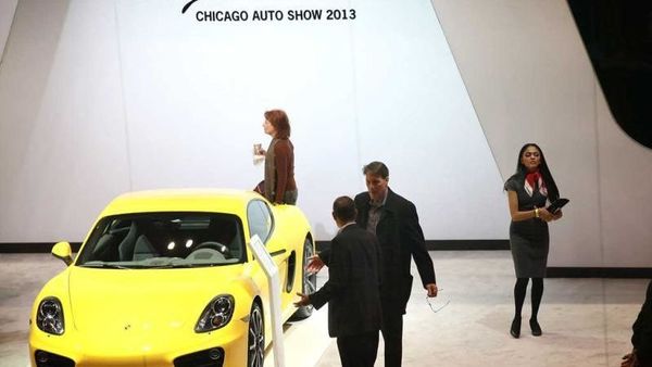Visitors look over the Porsche Cayman at the Chicago Auto Show in 2013. (File photo)