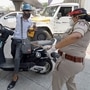 A police woman punishes a scooterist for flouting Covid-19 lockdown rules in Bengaluru on Saturday, May 8, 2021. (PTI)