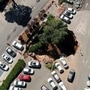 A drone photo shows a part of a parking lot that collapsed into a sinkhole outside a hospital in Jerusalem. (REUTERS)