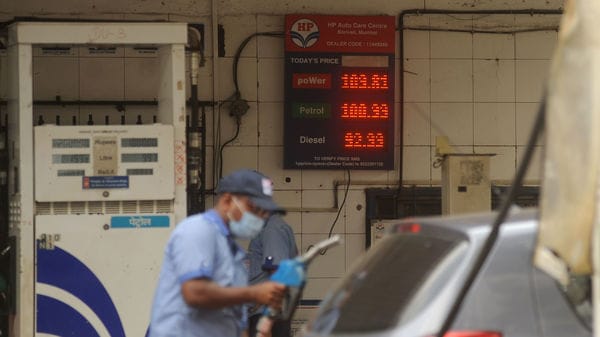 An attendant at a petrol pump fills the fuel tanks of motorists with rates displayed behind him on a digital screen in Mumbai. (File photo) (HT PHOTO)