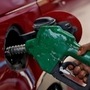 A worker holds a nozzle to pump petrol into a vehicle at a fuel station in Mumbai. (Reuters)